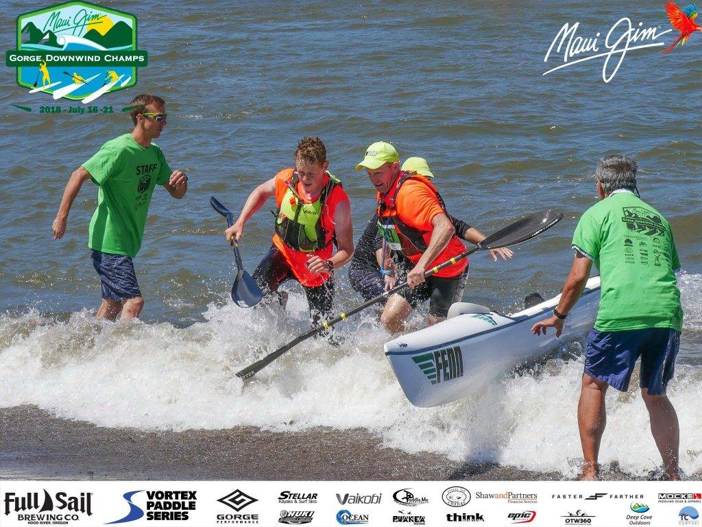 Jonas dismounting his boat and starting to run up the beach to trigger the timing chip at the finish of the Gorge Downwind Champs.