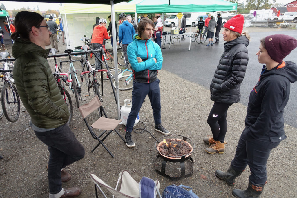 Rapha's Seattle manager Brandon Carmada (blue) chats at their firepit.